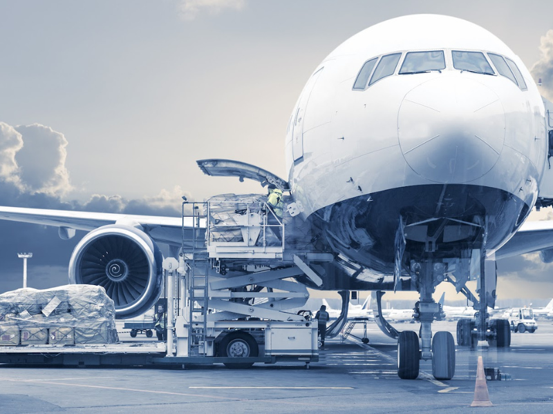 Aircraft sits at an airport with staff working around it