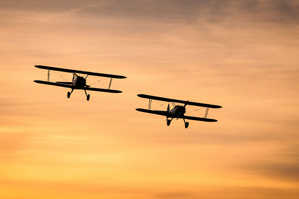 two planes flying during sunset
