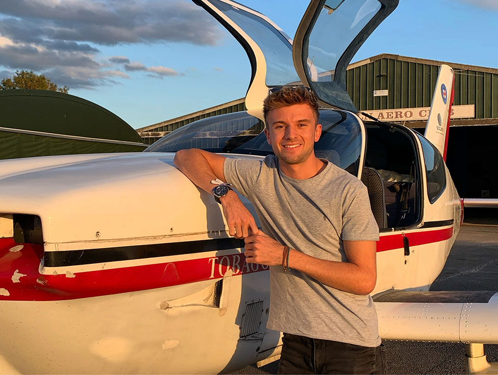 Christian Waddington standing by a plane