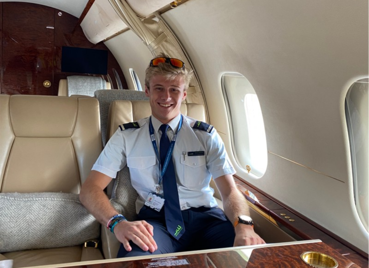 Young blonde pilot sat in a private jet